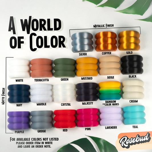 "A World of Color guide for Rosebud All-Seeing Eye Planter showing various color options including matte finishes like white, terracotta, and navy, as well as metallic finishes like silver, copper, and gold, emphasizing planters, excellent drainage, multiple colors, plant lover, home decor."