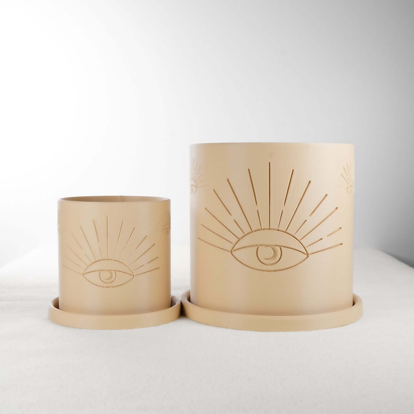 Two beige All-Seeing Eye Planters made of 3D printed PLA with intricate eye design, showcasing both small and large sizes. Perfect for plant lovers and home decor enthusiasts, these planters offer excellent drainage and minimalistic, modern appeal. Available in multiple colors for a personalized touch.