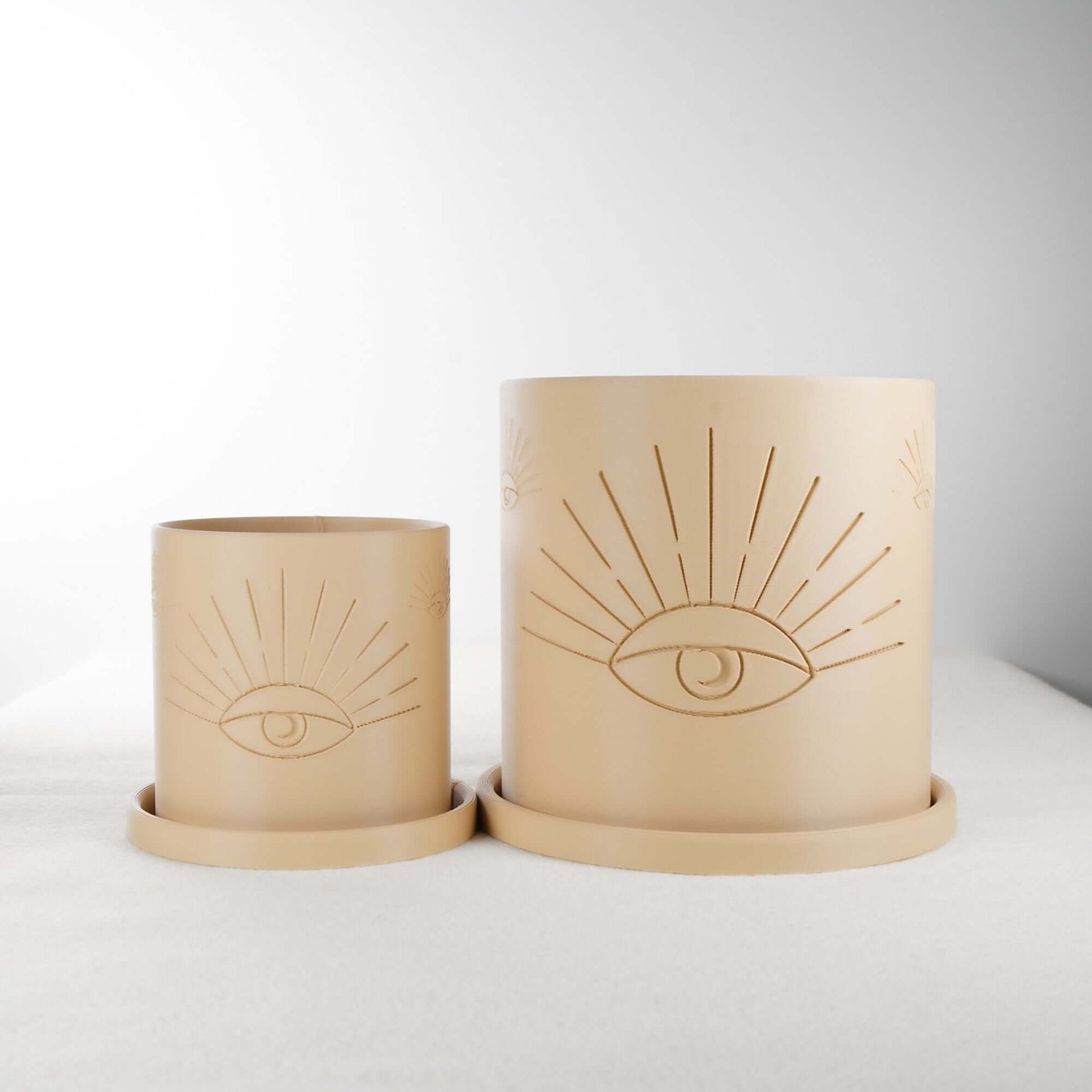 Two beige All-Seeing Eye Planters made of 3D printed PLA with intricate eye design, showcasing both small and large sizes. Perfect for plant lovers and home decor enthusiasts, these planters offer excellent drainage and minimalistic, modern appeal. Available in multiple colors for a personalized touch.
