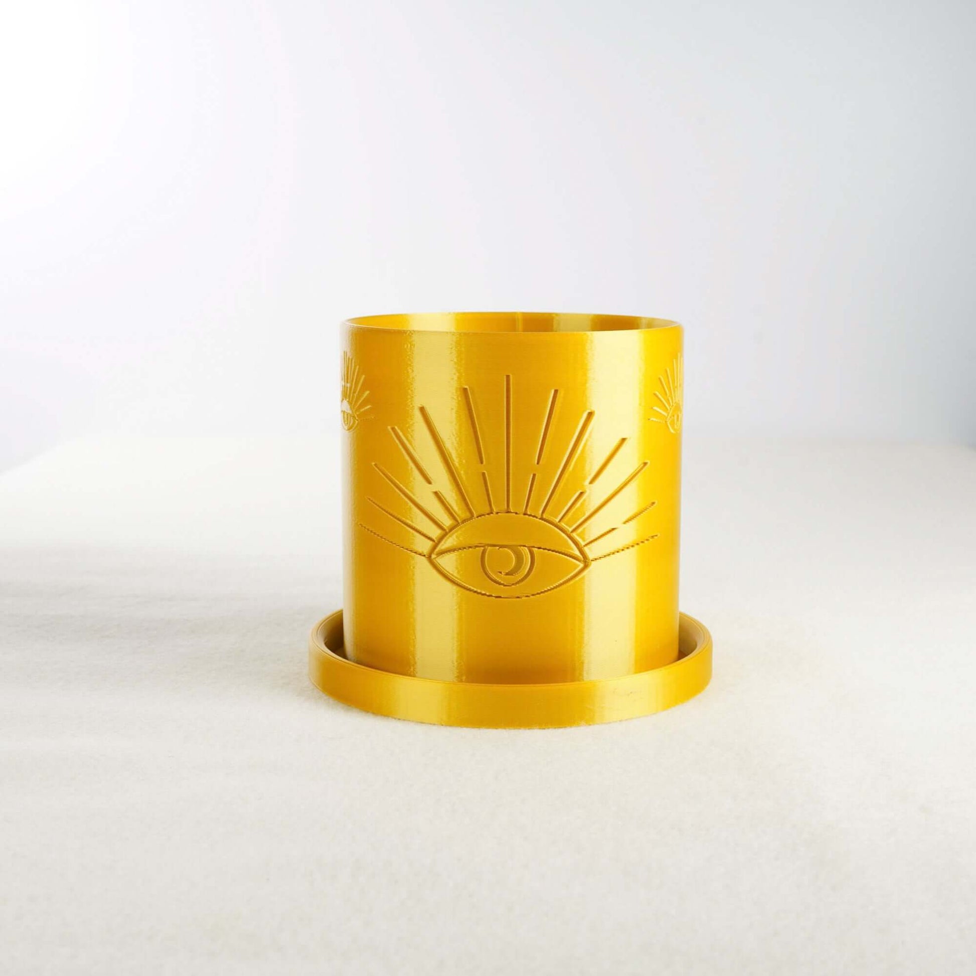 Bright yellow All-Seeing Eye 3D printed planter with excellent drainage, perfect for plant lovers seeking modern, minimal home decor. Planter features raised eye design and multiple color options. Made from biodegradable PLA material.