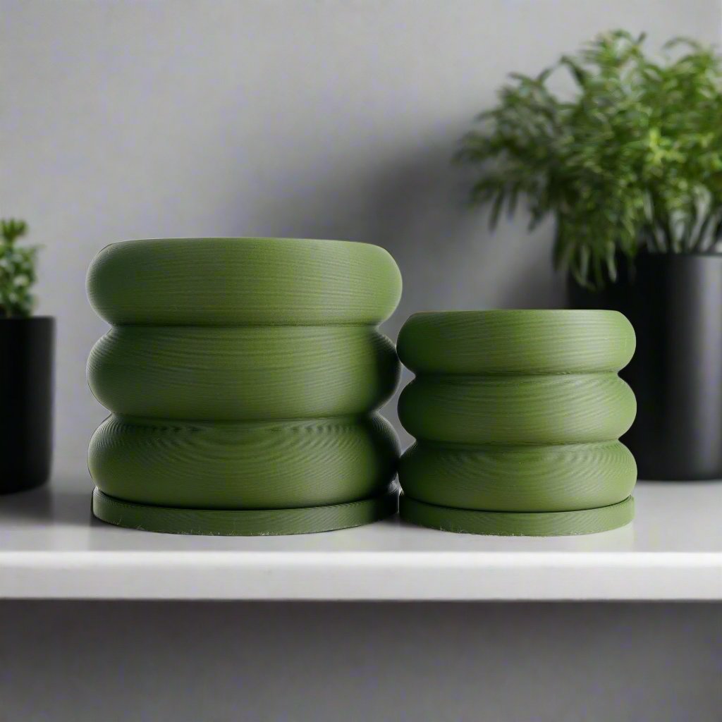 Bubble Planter in a matte green finish resembling a playful stack of donuts; perfect for adding modern minimalism and charm to any home decor. Two different sized planters showcased, offering excellent drainage for plant lovers, making an ideal choice for healthy and vibrant botanicals in multiple colors.