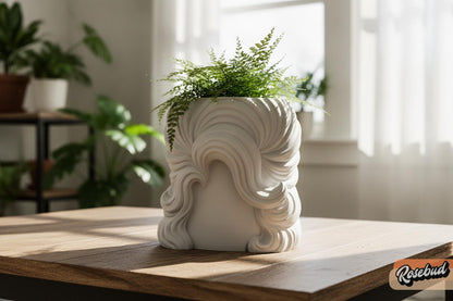 White 3D printed country diva wig planter with sculpted flowing curls holding a green fern on a wood table