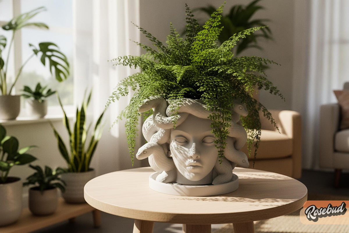 White Medusa face planter with detailed snake hair and a green fern styled as gothic indoor plant decor.