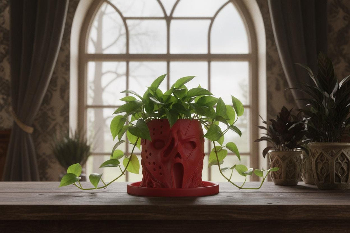 Red horror-inspired face planter with trailing pothos and matching drip tray in gothic home decor.